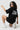 Woman wearing a black oversized t-shirt with 'TIMELESS' print on a white background