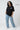 Person wearing an oversized black t-shirt with 'TIME LESS' text and light blue jeans on a white background.